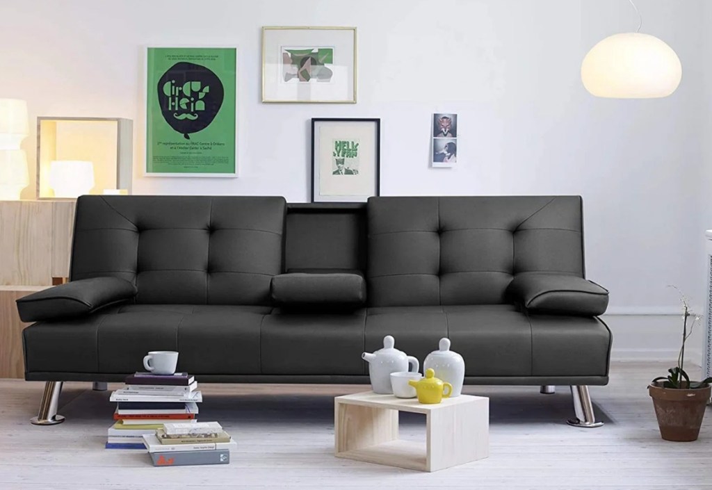 Black couch with books in front of it