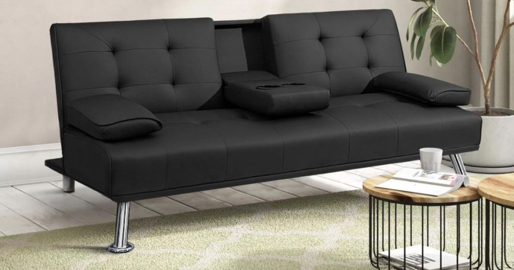 Black sofa with silver legs and a table in front of it