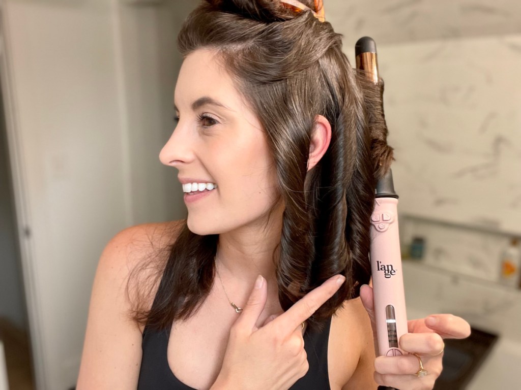 woman curling her hair with the le pirouette curling iron and curler by L'ange