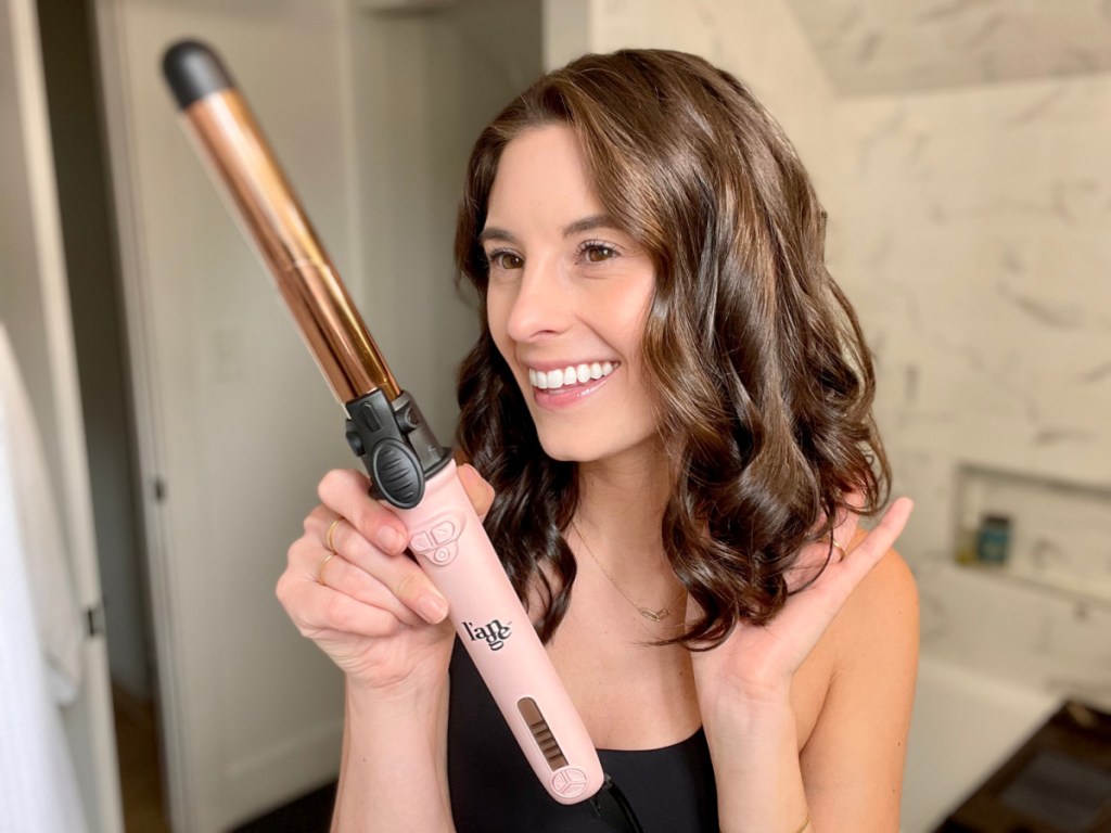 Woman checking out her gorgeous curls courtesy of Le Pirouette Curling Iron by L'Ange