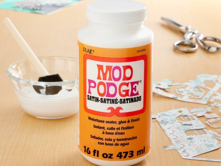 16oz bottle of mod podge satin waterbase sealer on table with crafting supplies