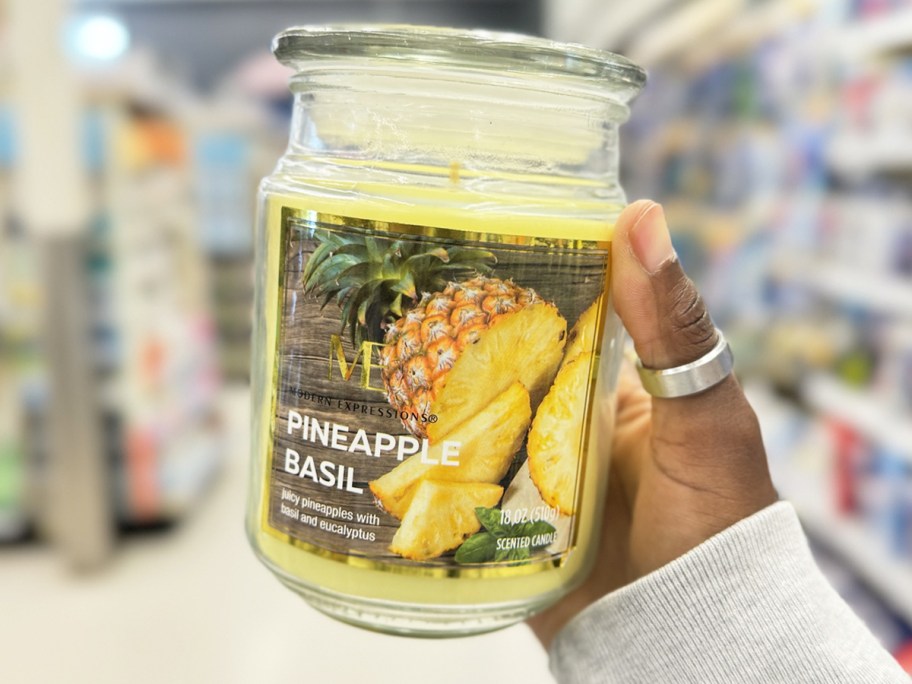 hand holding up a pineapple scented jar candle