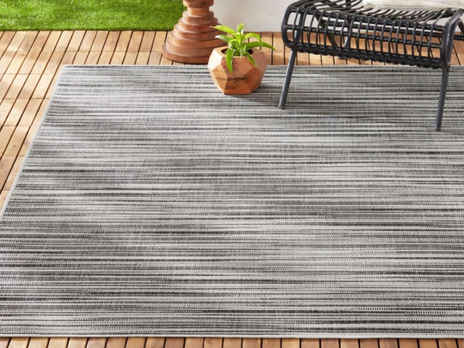grey striped patio area rug with chair on top