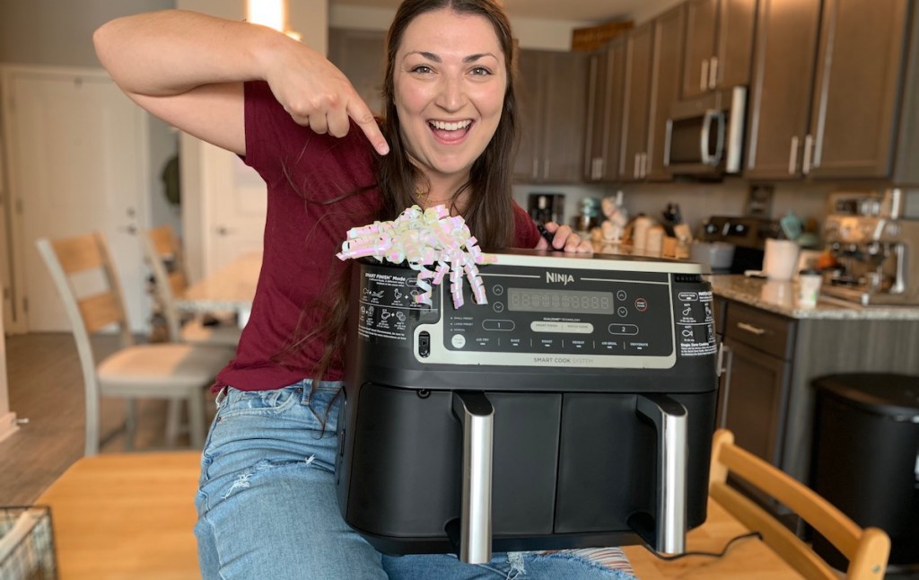 woman with ninja foodi air fryer on lap with bow