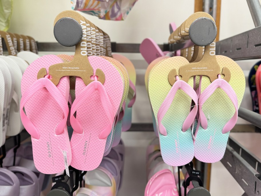 pairs of pink and pastel rainbow flip flops