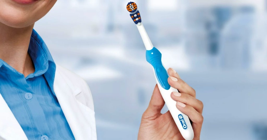 woman holding oral-b 3d white battery toothbrush