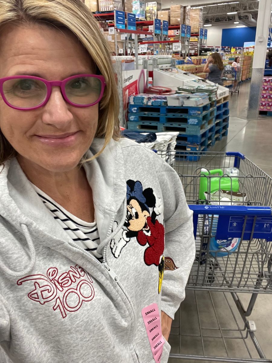 A woman in a Disney zip up sweatshirt