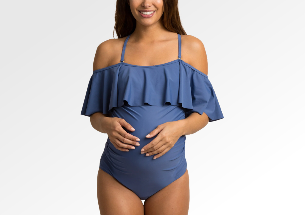 Woman wearing a maternity swimsuit with ruffle top from pink blush maternity