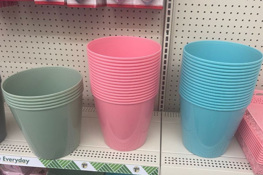3 stack of small plastic waste baskets on a store shelf