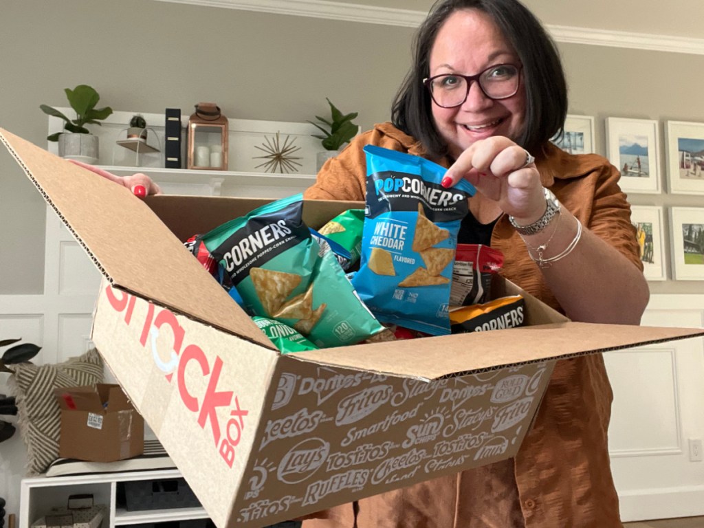 woman holding snack box from Amazon filled with bags of popcorners