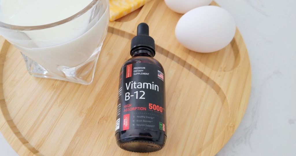  Vitamin b12 bottle with dropper on wood plate with egg cheese and glass of milk