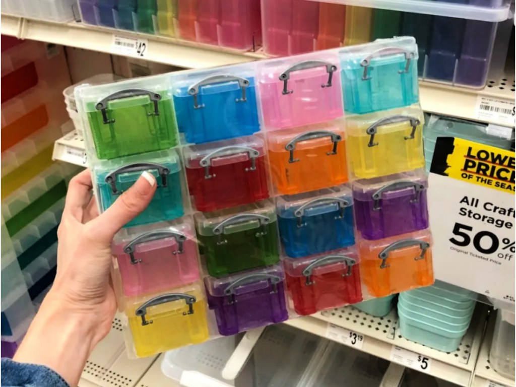 woman in michaels store holding up 16 tiny boxes in different colors