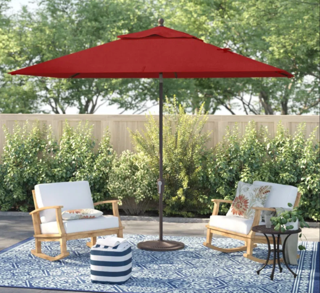 A rectangular patio umbrella shading two patio chairs