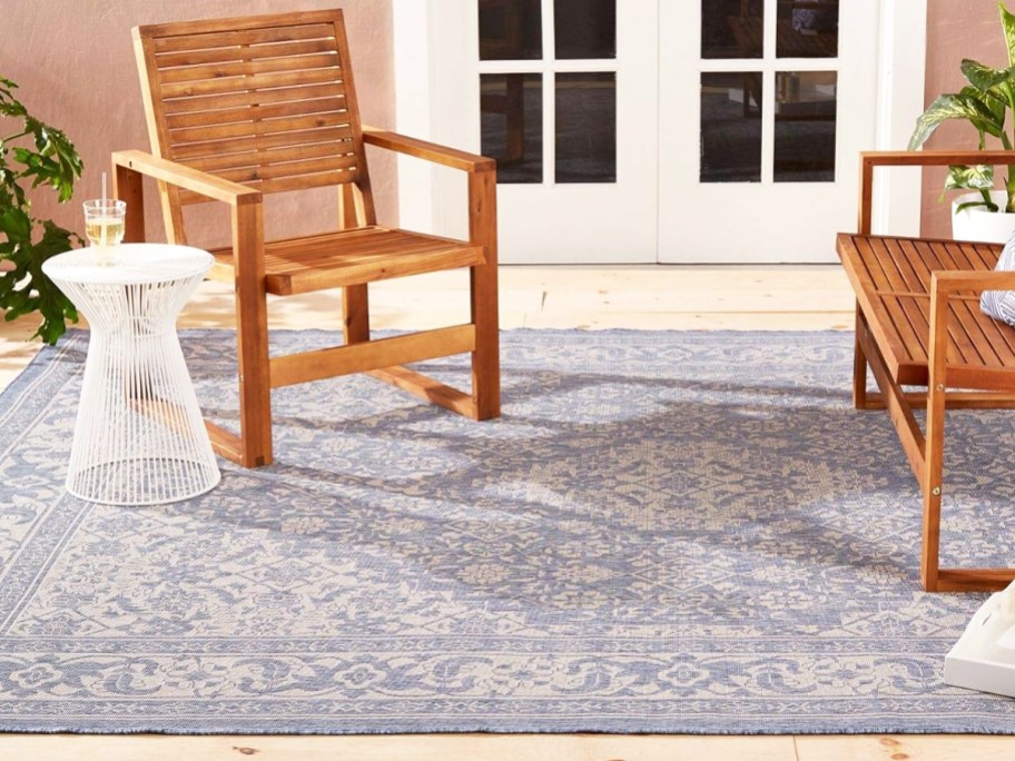 blue and white outdoor rug with wood chairs on top