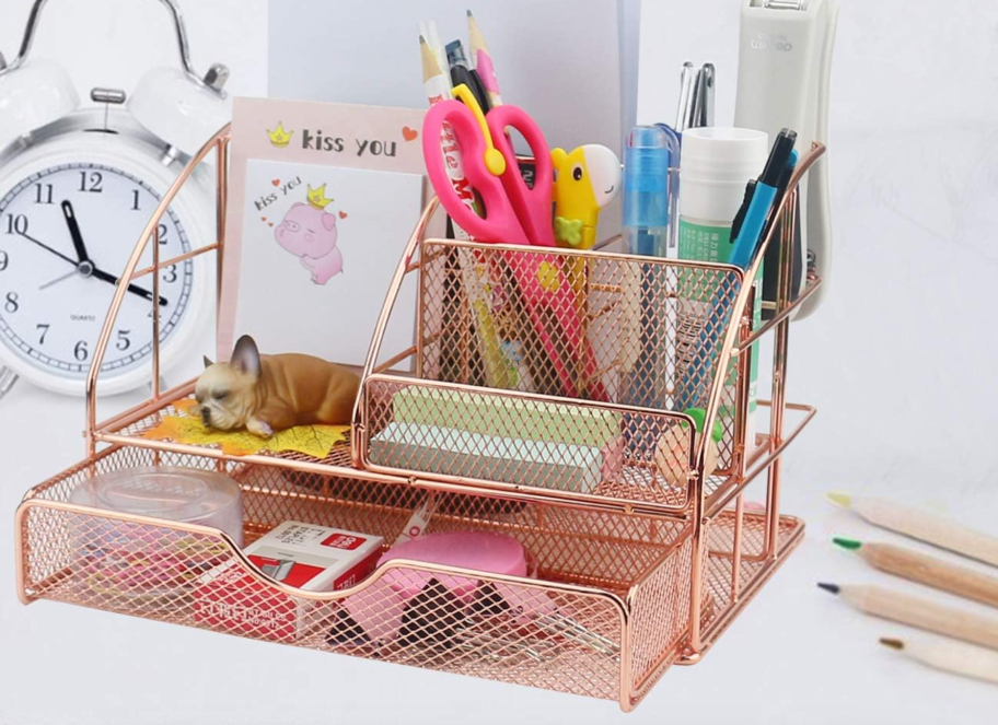 rose gold desk organizer sitting on table with pencils, scissors, and paper in it