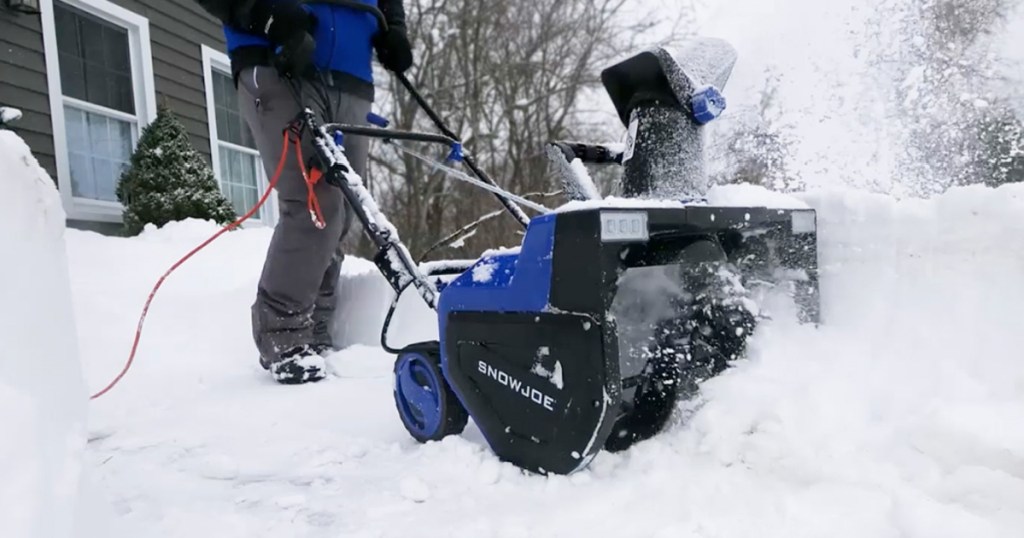 Person blowing snow using electric snow Joe snow blower