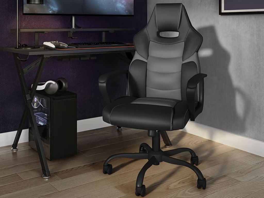 A Gaming chair from staples near a computer desk with a gaming setup