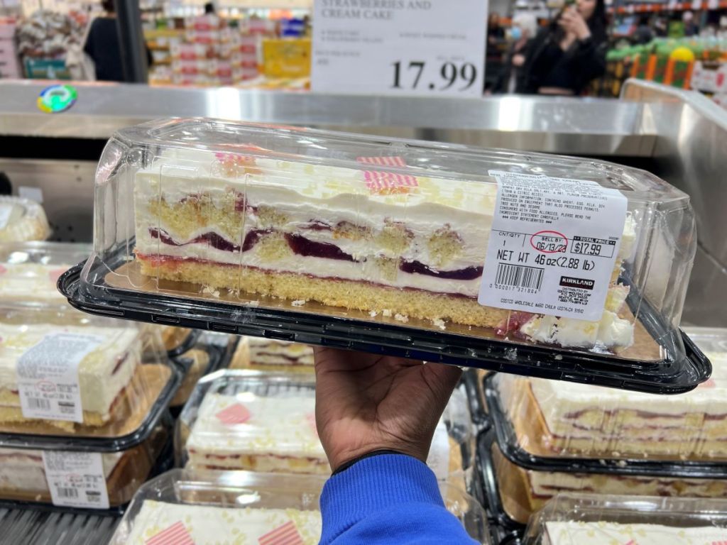 Hand holding a long strawberry cake