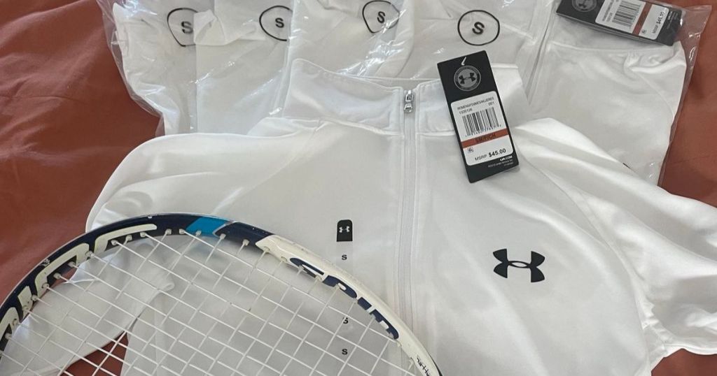 4 white Under Armour 1/2 zip shirts with a tennis racket