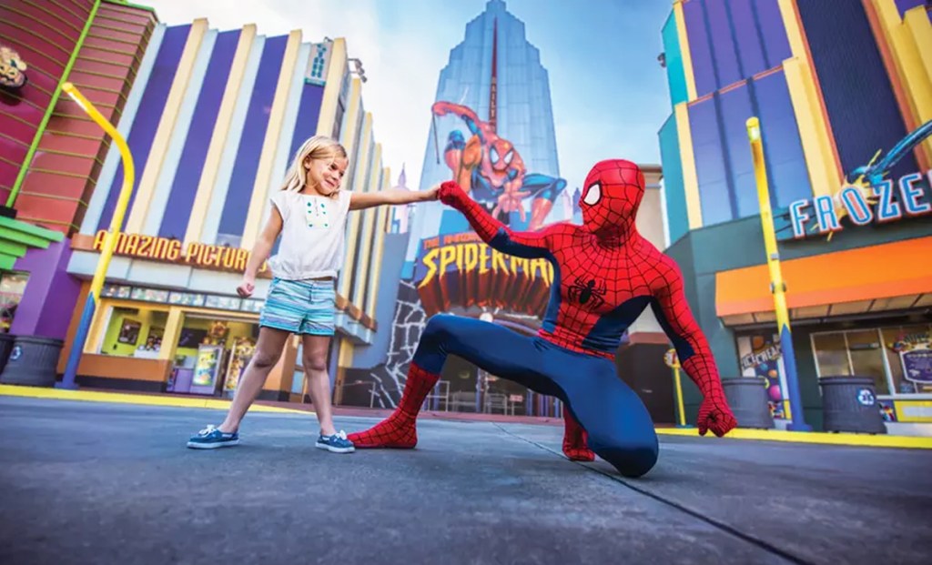 girl posing for photo with spider-man