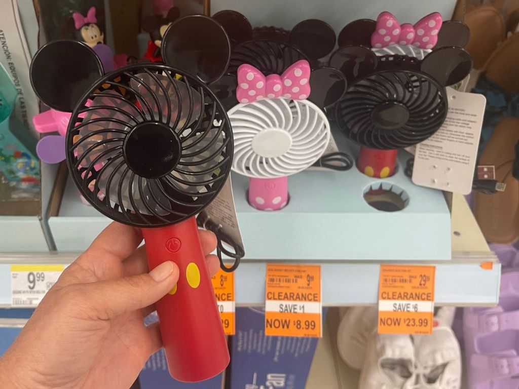 hand holding up a Mickey Mouse personal USB fan at Walgreens in front of a shelf with Mickey and Minnie USB fans