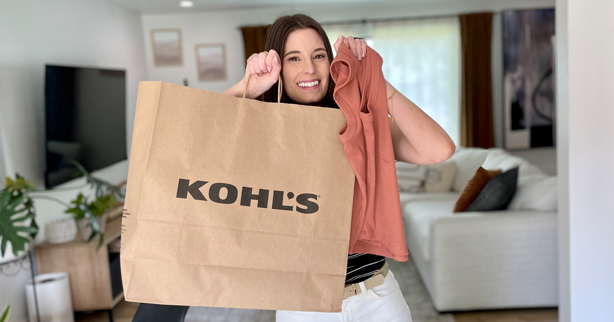 Woman holding clothing and a kohl's bag in her living room