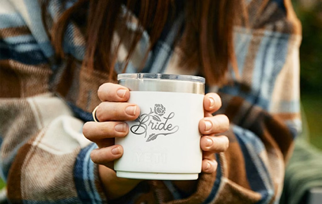 woman holding a white yeti lowball that says bride on it