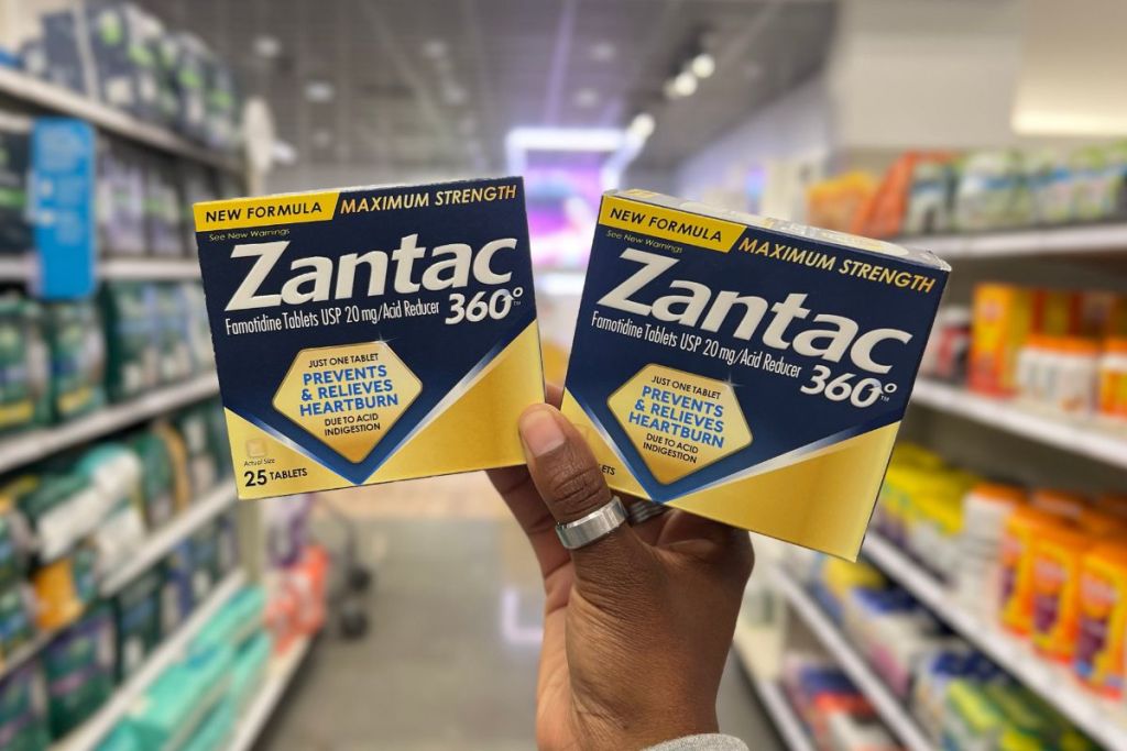 Woman's hand holding 2 boxes of Zantac 360 Heartburn Prevention & Relief Tablets at Target