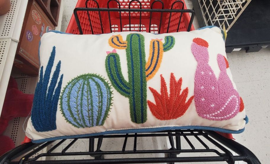 a cactus throw pillow in a shopping cart