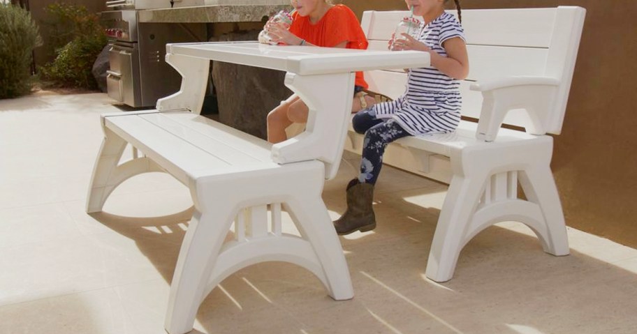 two kids sitting on white qvc bench and table