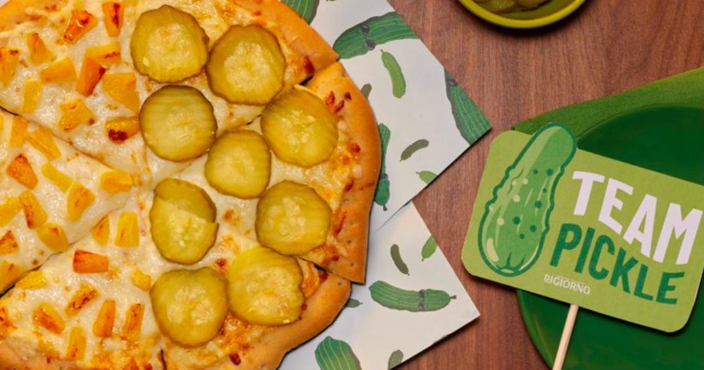 a half pineapple, half pickle pizza with a sign on the right declaring team pickle