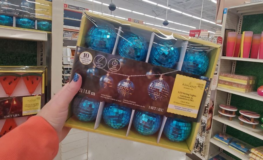 womans hand displaying a box of blue disco ball string lights