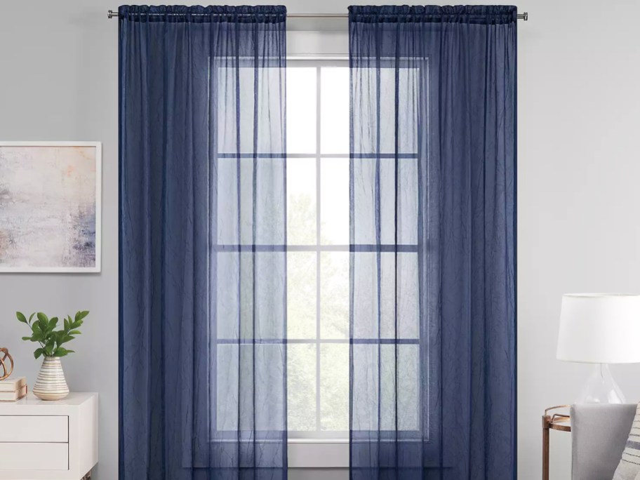 sheer navy blue curtain panels over window