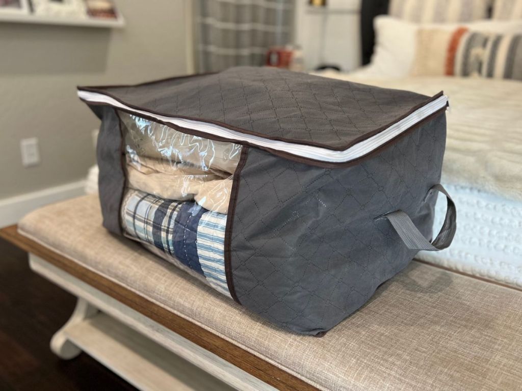 a storage box on a bench in front of a bed