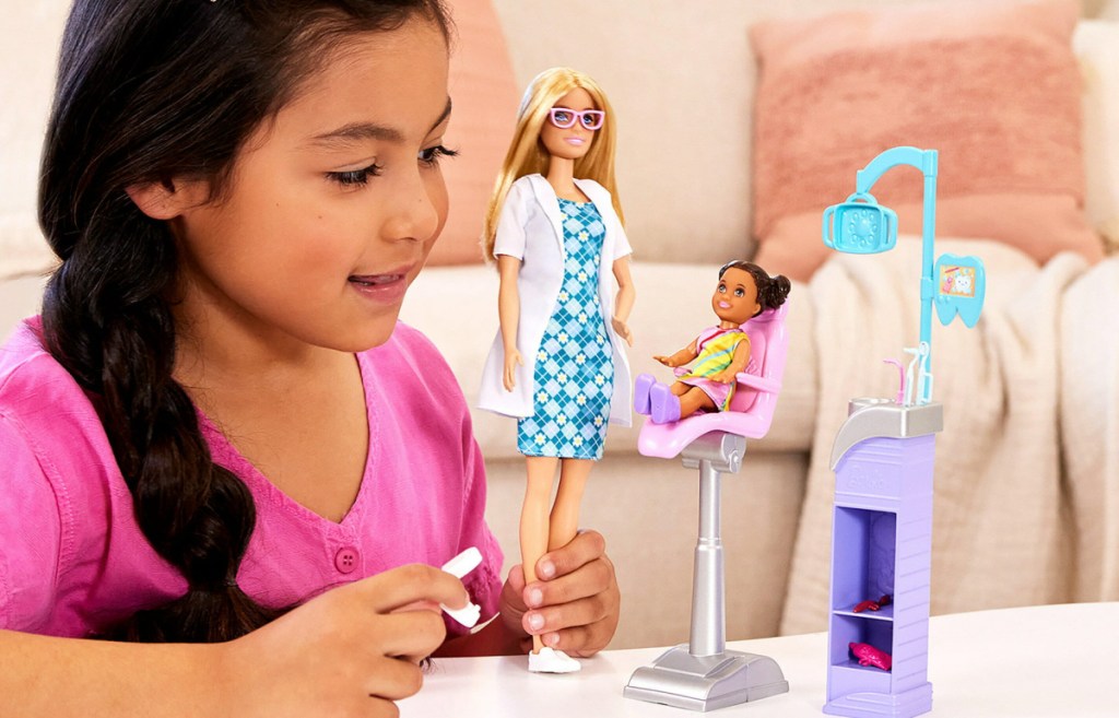 girl playing with dentist barbie