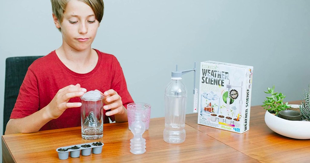 child playing with green science weather kit