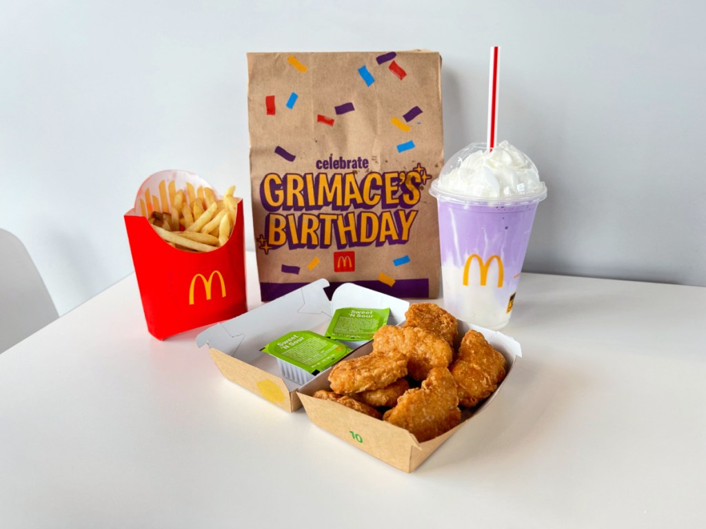 grimace mcdonalds meal displayed on a table near a bag