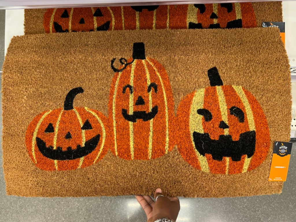 hand holding pumpkin doormat from target