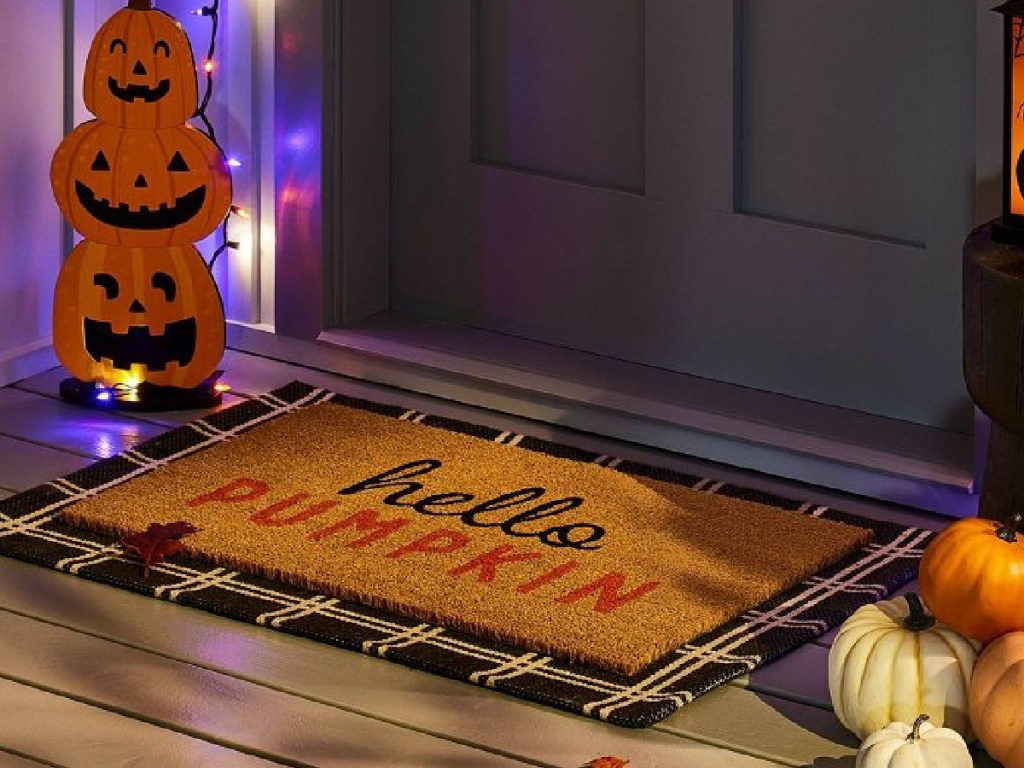 hello pumpkin doormat displayed in front of door