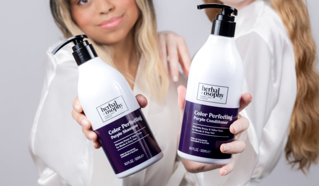 two women holding shampoo and conditioner bottles