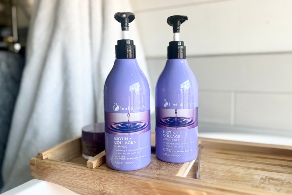 purple bottles of shampoo & conditioner on wood tray