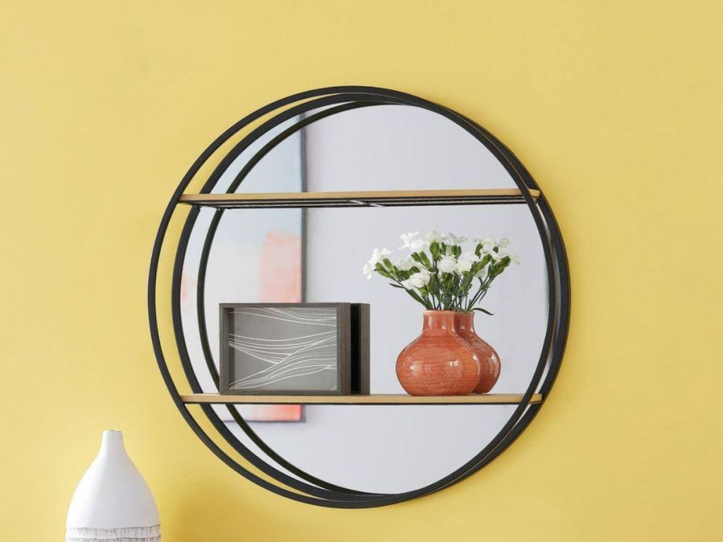 black circle frame mirror with 2 shelves on yellow wall