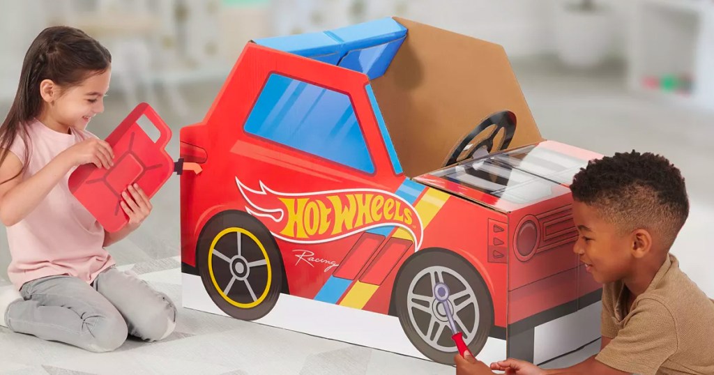 two kids playing with hot wheels cardboard playset