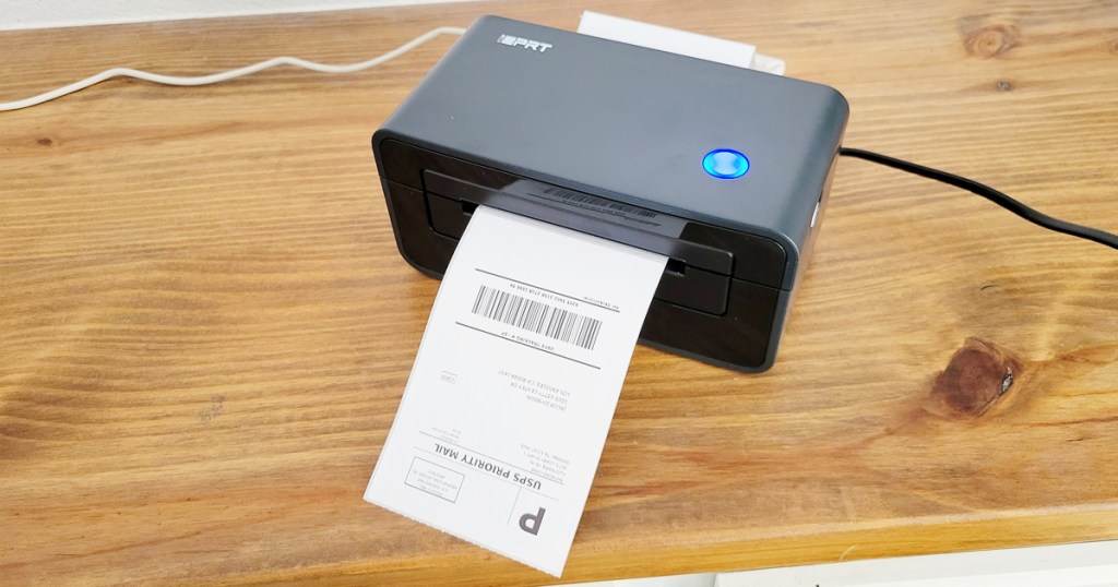printing a shipping label from a black printer on wood desk