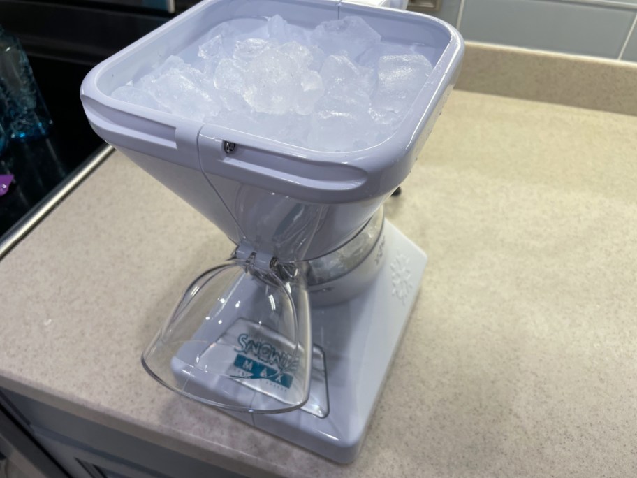 Little Snowie MAX Shaved Ice Machine filled with ice and sitting on a countertop