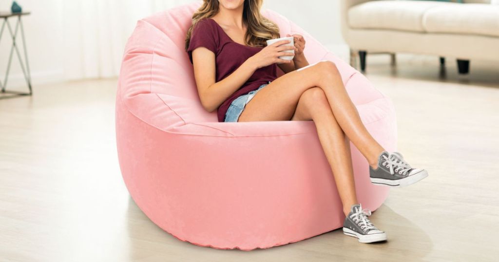 woman sitting in pink beanless bag chair