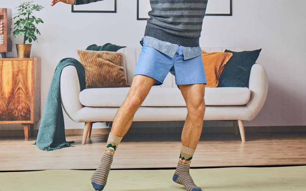 man sliding across room in socks and shorts