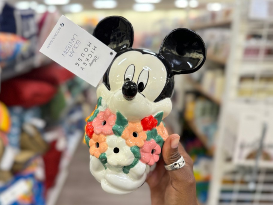 hand holding a ceramic Mickey Mouse with flowers solar light