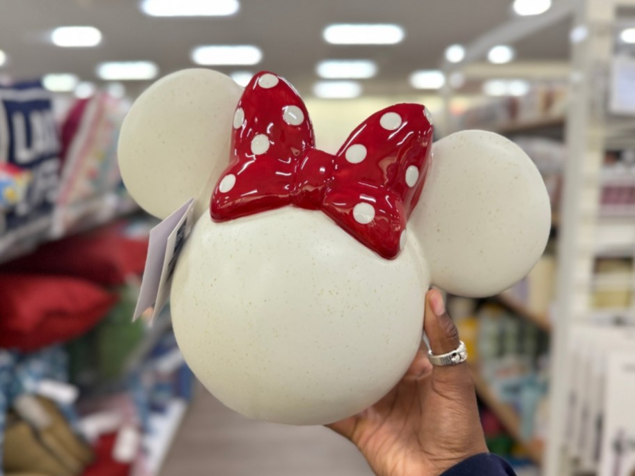 hand holding a white and red Minnie Mouse head shaped ceramic planter
