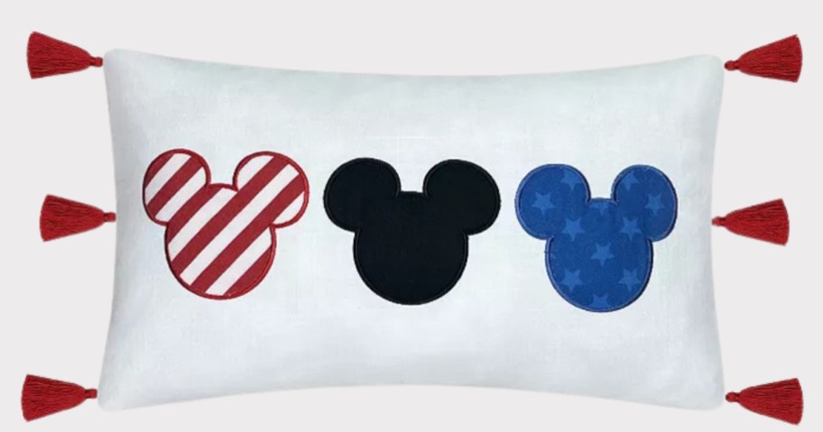 white rectangle pillow with red tassels and red & white, blue and black Disney Mickey heads